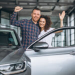 Young family buying a car in a car showroom